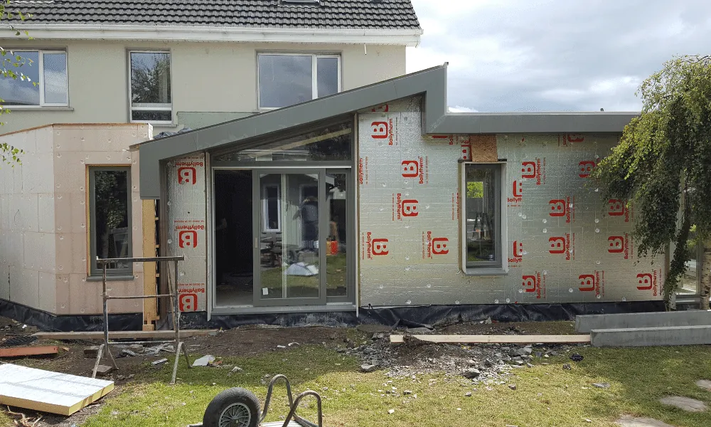 A house extension under construction, with insulation boards fixed to the walls